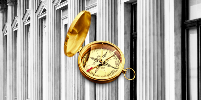 A gold compass in front of a building, symbolizing guidance in tech sales, sales career, and sales strategies.